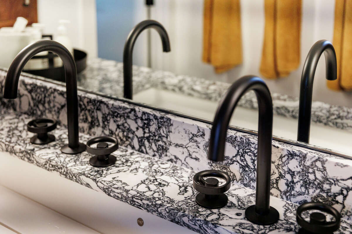The primary bathroom has a single, elongated trough sink and granite countertops.
