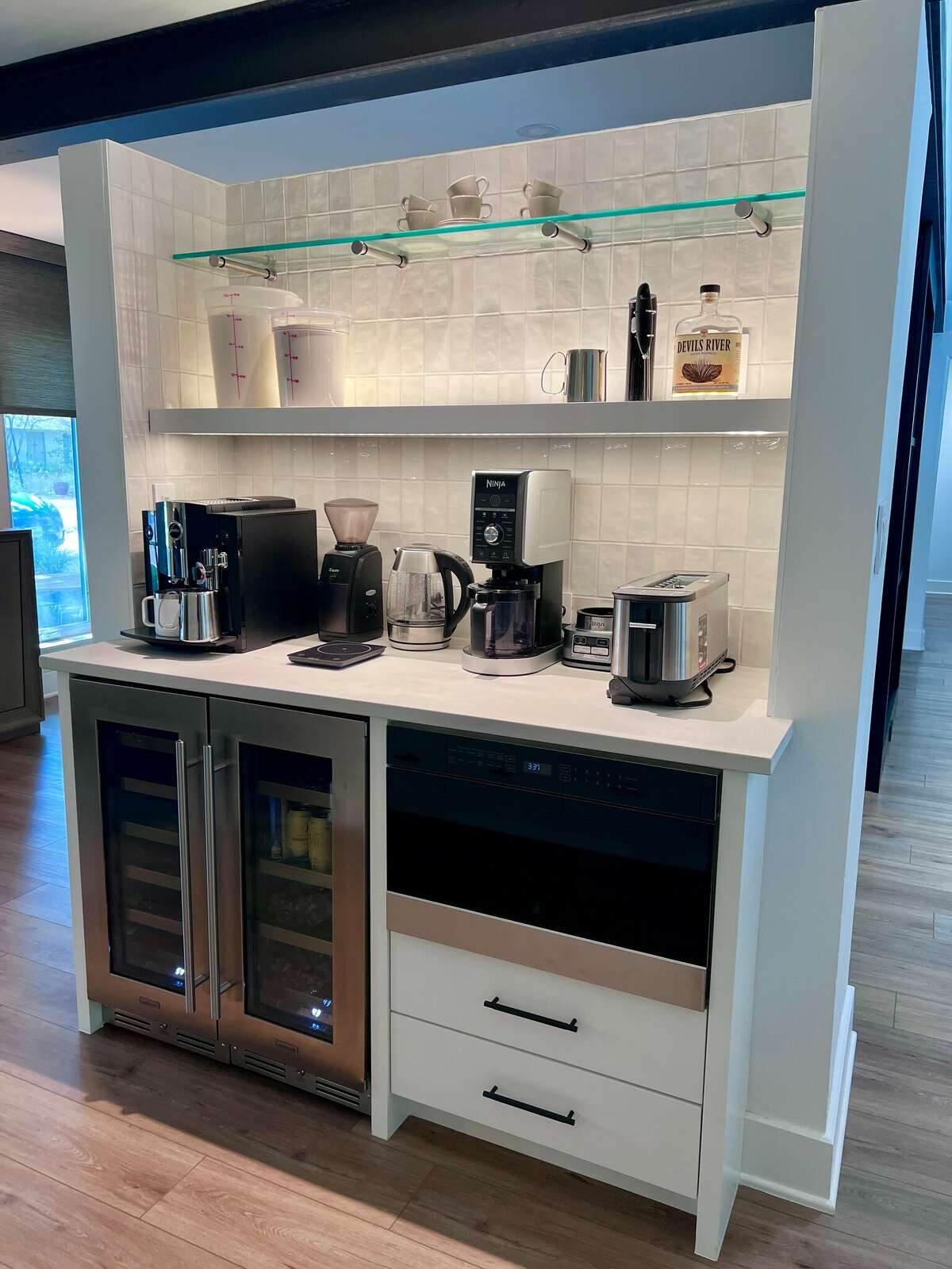 Another way they broke up the space was by building a standalone, U-shaped coffee and wine bar between the kitchen and the dining room/music room. But the structure doesn’t reach all the way to the ceiling, so it still helps emphasize the room’s openness. 