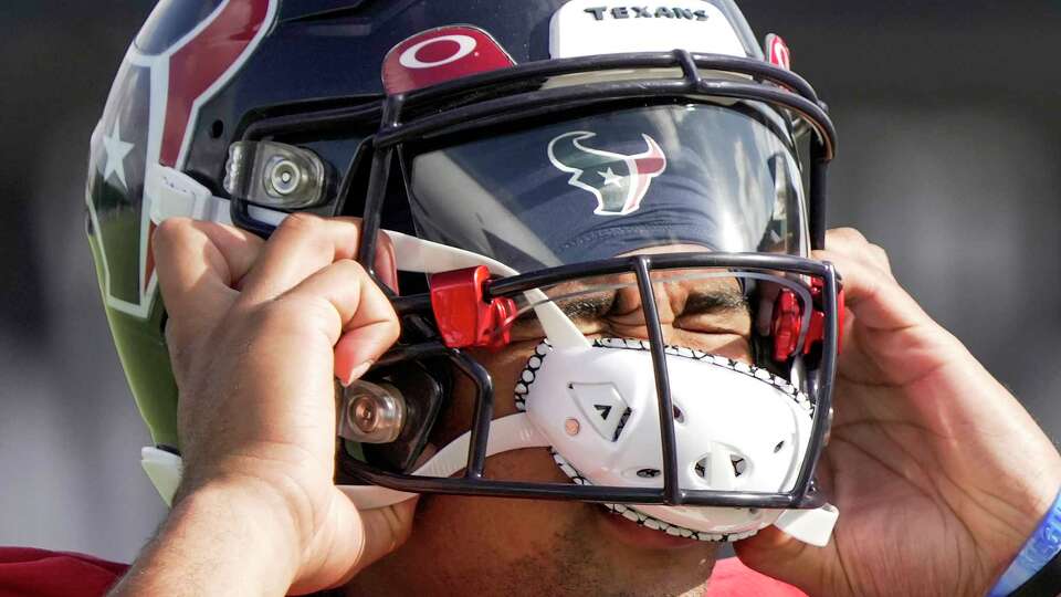 Houston Texans quarterback C.J. Stroud dons his helmet as he gets ready for practice during an NFL training camp Tuesday, Aug. 8, 2023, in Houston.