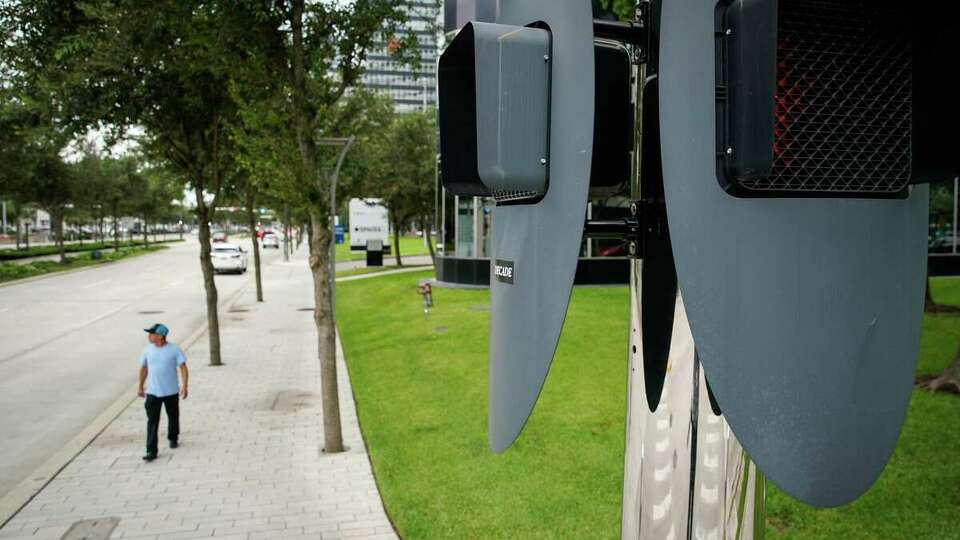 A pedestrian walks down Post Oak Boulevard, a shaded thoroughfare in Houston's Uptown TIRZ.