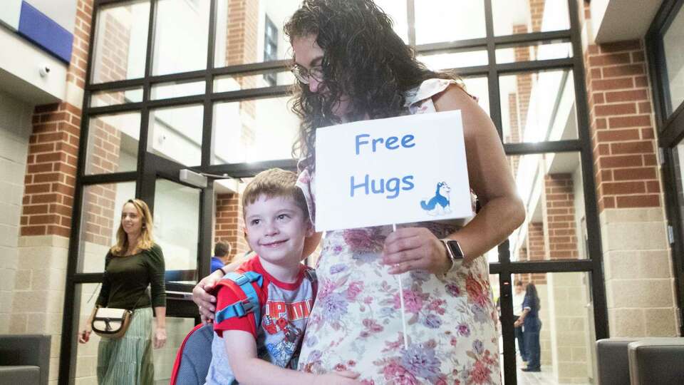 Samuel Daley takes Counselor Laura Vargas up on her sign on the first day of school at Conroe ISD's newly opened Hines Elementary, Wednesday, Aug. 9, 2023, in Spring.