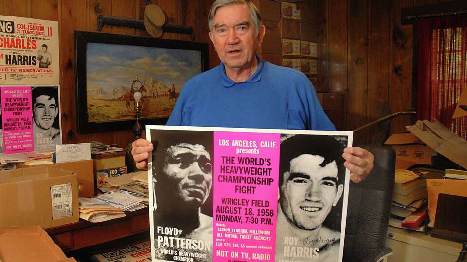 Cut & Shoot resident Roy Harris holds the World Championship boxing poster. Harris fought Floyd Patterson for the World Heavyweight Championship in 1958.
