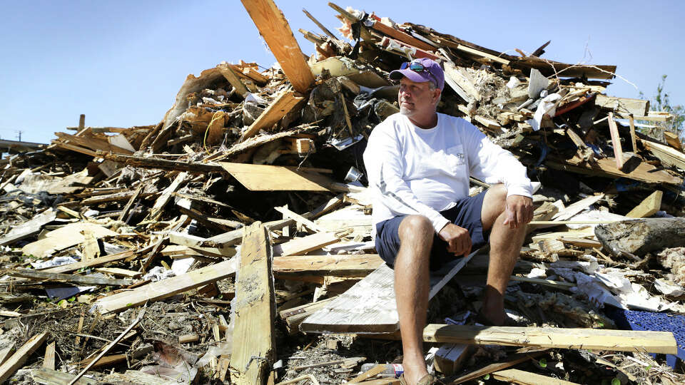 Gray Gant, 51, who grew up in Port Aransas, Texas, sits on the pile of rubble that was the house he lived in and stayed in when hurricane Harvey hit, on Wednesday, Oct. 25, 2017. He received a letter of denied coverage from FEMA.