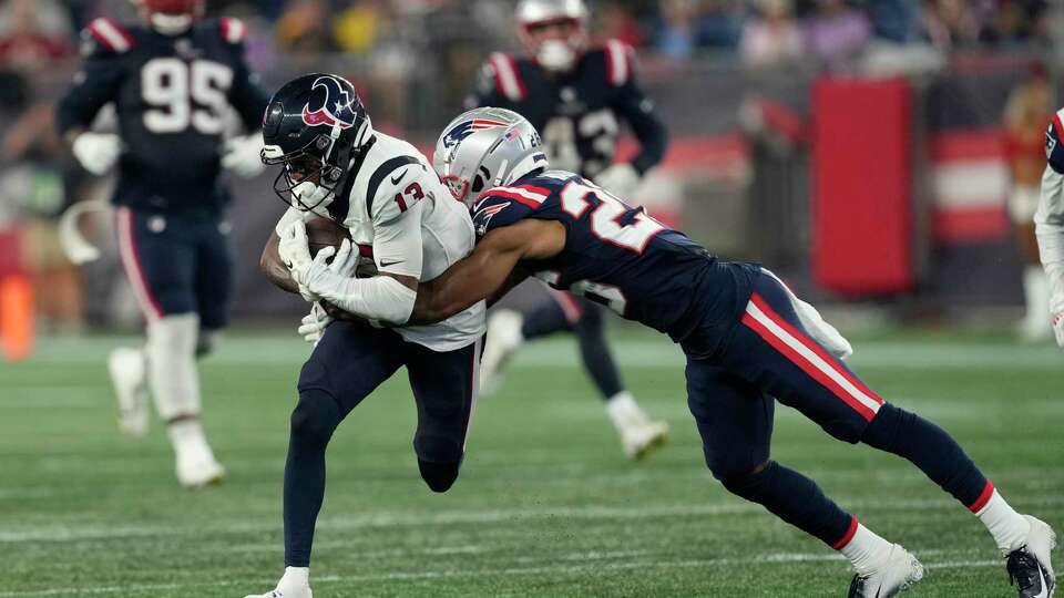 Houston Texans wide receiver Tank Dell (13) is tackled by New England Patriots cornerback Shaun Wade (26) during the first half of a NFL pre-season game at Gillette Stadium, Thursday, Aug. 10, 2023 in Foxborough.