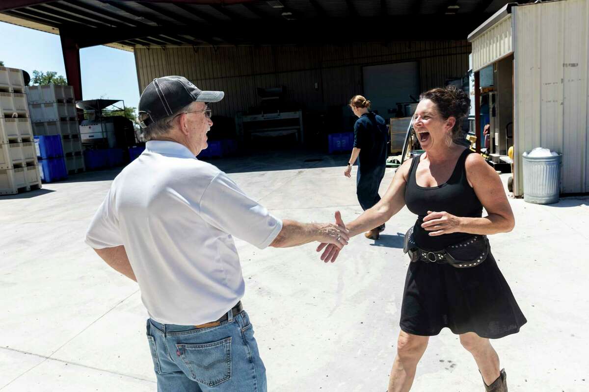 Lisa Kennelly of Diamond Vineyards greets Dr. Bob Young, co-owner and winemaker at Bending Branch Winery in Comfort, as she delivers grapes to the winery.