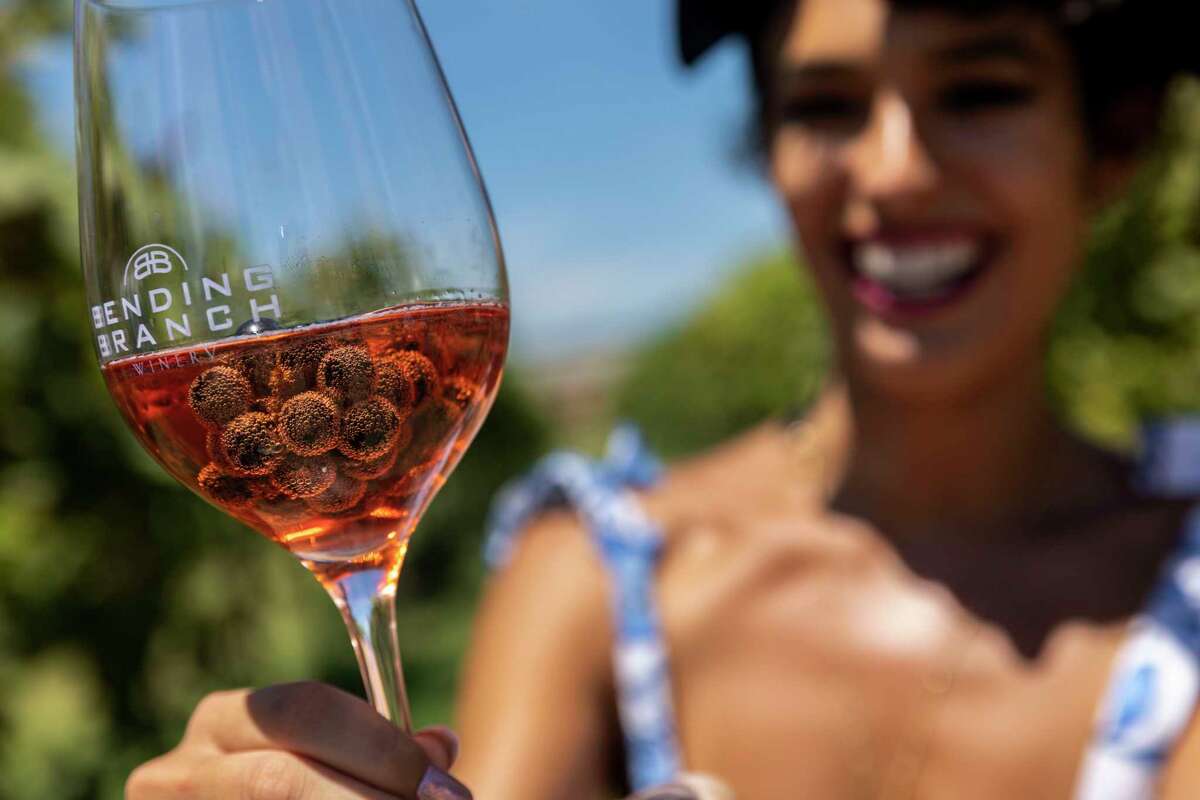 Travel influencer Jessica Serna of Dallas shows off the bubbles on the grapes in her wine glass at Bending Branch Winery in Comfort.