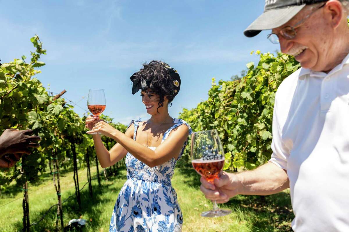 Travel influencer Jessica Serna of Dallas checks out the bubbles on the grapes in her glass with Dr. Bob Young, co-owner and winemaker at Bending Branch Winery in Comfort.