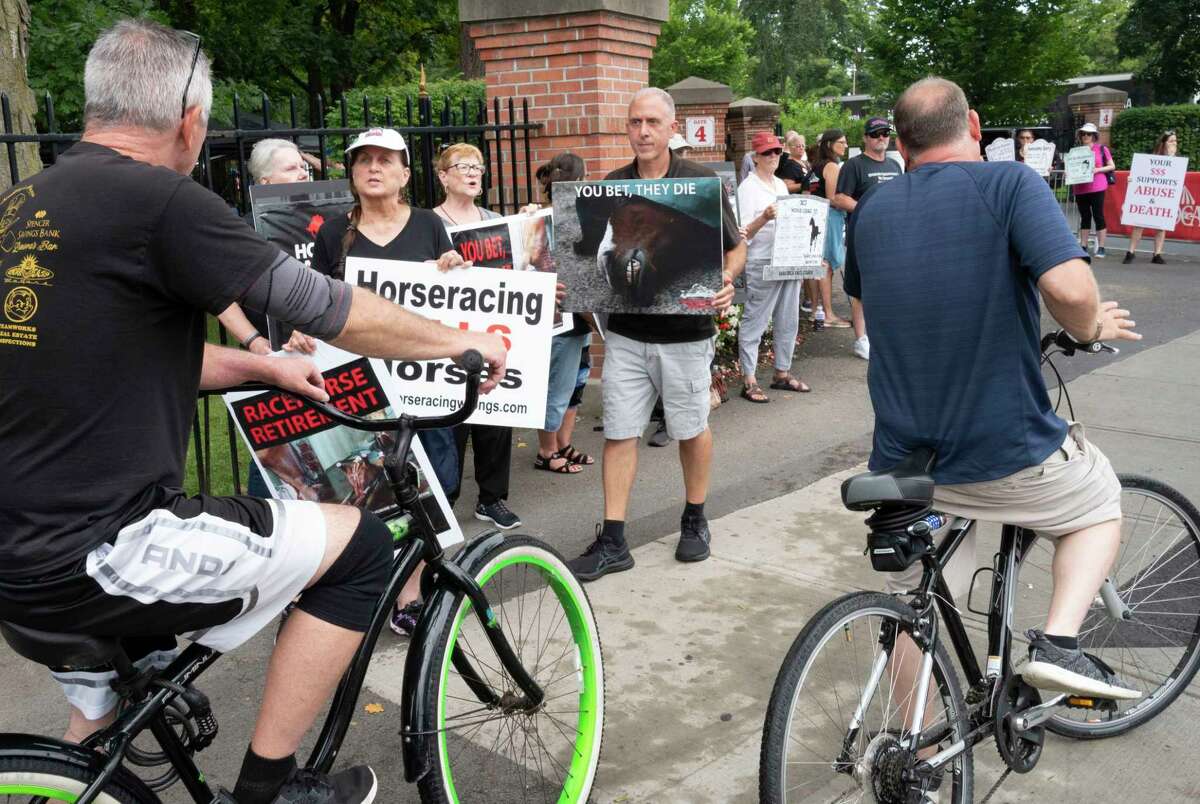Protesters hold signs outside the Saratoga Racetrack in Saratoga Springs, N.Y. on Sunday, Aug. 13, 2023. The protest was organized by the organization Horseracing Wrongs. Founder and President Patrick Battuello stands in center. (Lori Van Buren/Times Union)