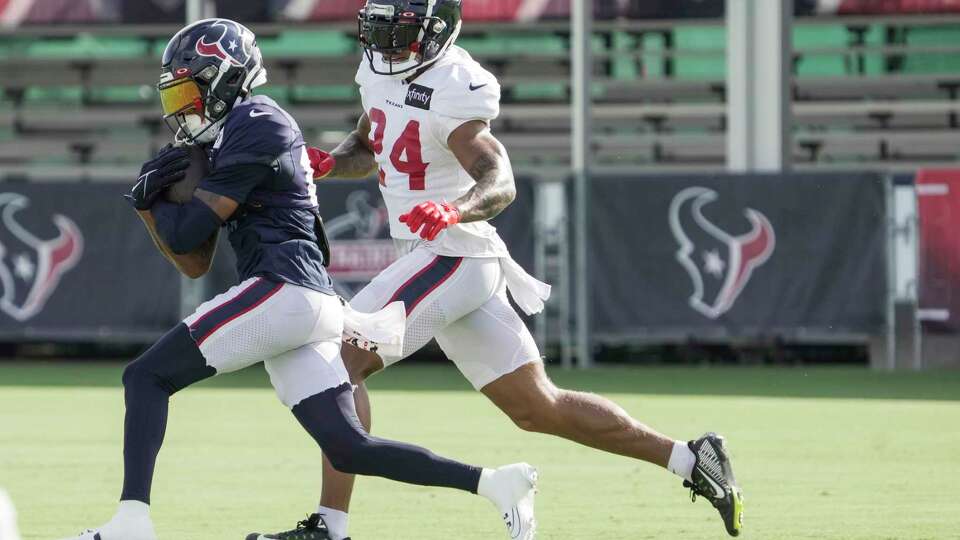 Houston Texans wide receiver Tank Dell (13) runs the ball after making a catch against cornerback Derek Stingley Jr. (24) during an NFL training camp Monday, Aug. 14, 2023, in Houston.