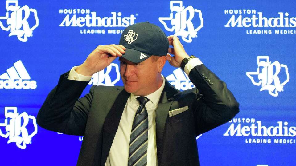 Tommy McClelland enjoys a photo opportunity at the podium during a press conference announcing McClelland as Rice University's next director of athletics Tuesday, Aug. 15, 2023.
