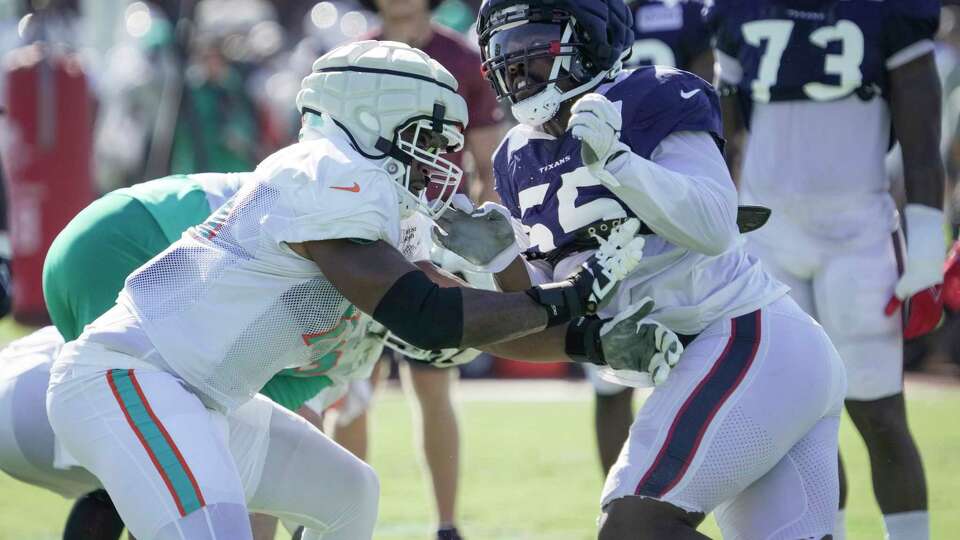 Miami Dolphins guard Austin Jackson (73) and Houston Texans defensive end Jerry Hughes (55) battle it out during an NFL training camp Wednesday, Aug. 16, 2023, in Houston.