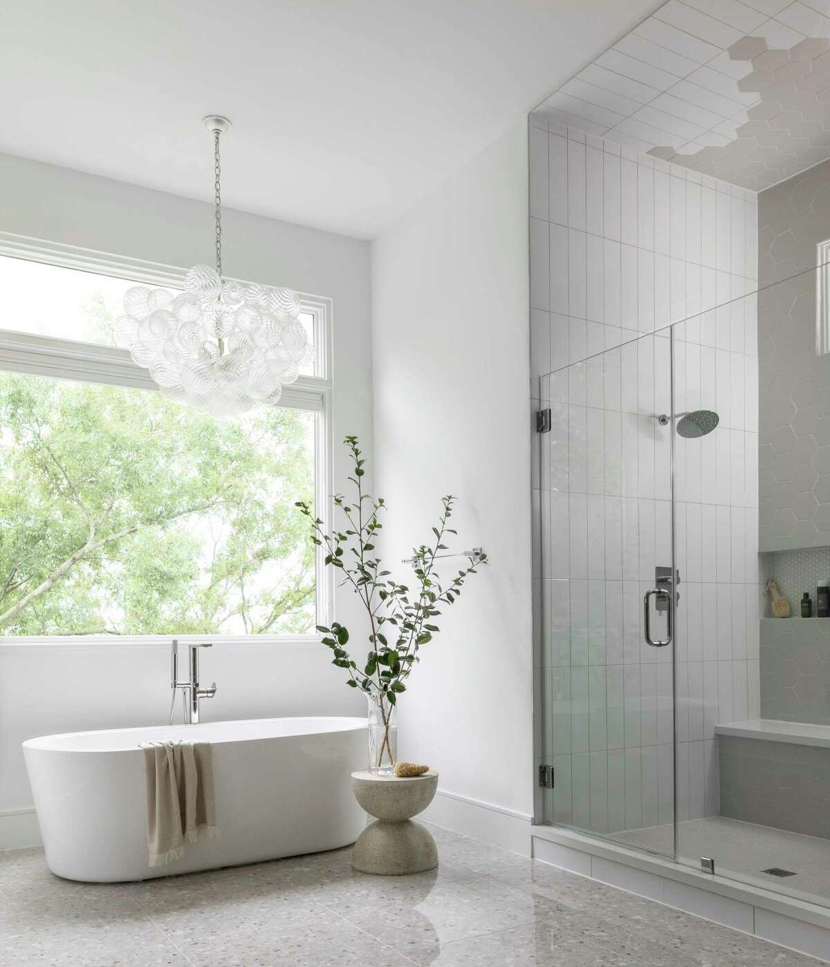 The primary bathroom's shower uses two types of tile, one for the side walls and part of the ceiling and the other for the floor, back wall and remainder of the ceiling.