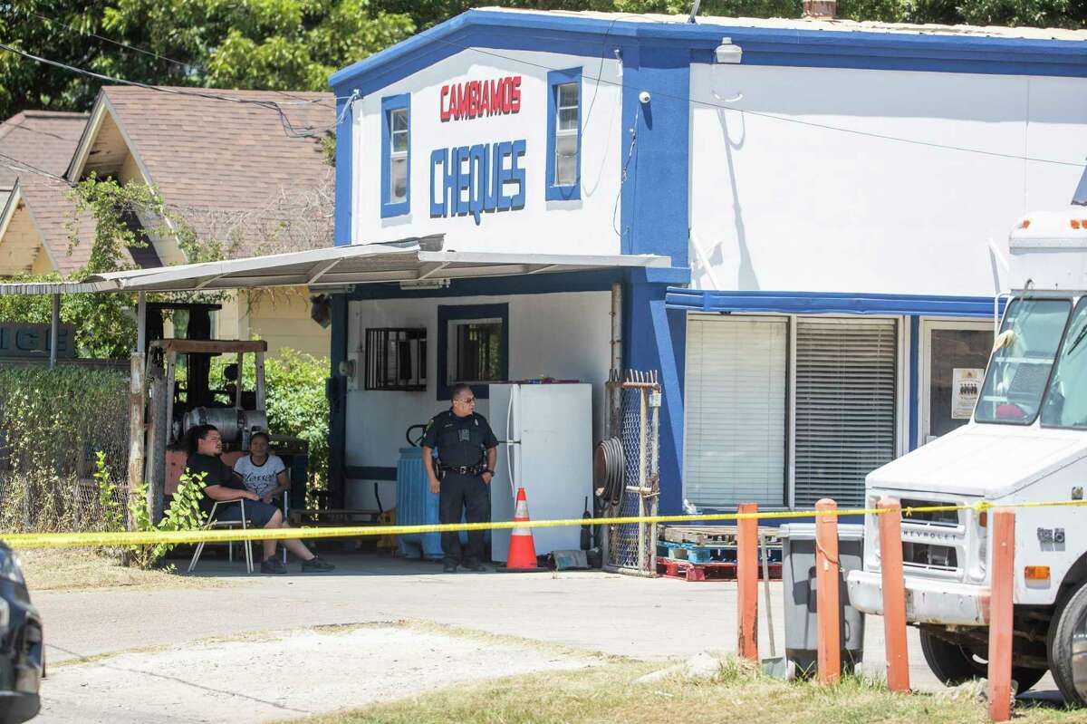 Officers with the Houston Police Department investigate the scene where two alleged robbers were fatally shot at Ruiz Cash & Canny Co., Wednesday, Aug. 16, 2023, in Houston.