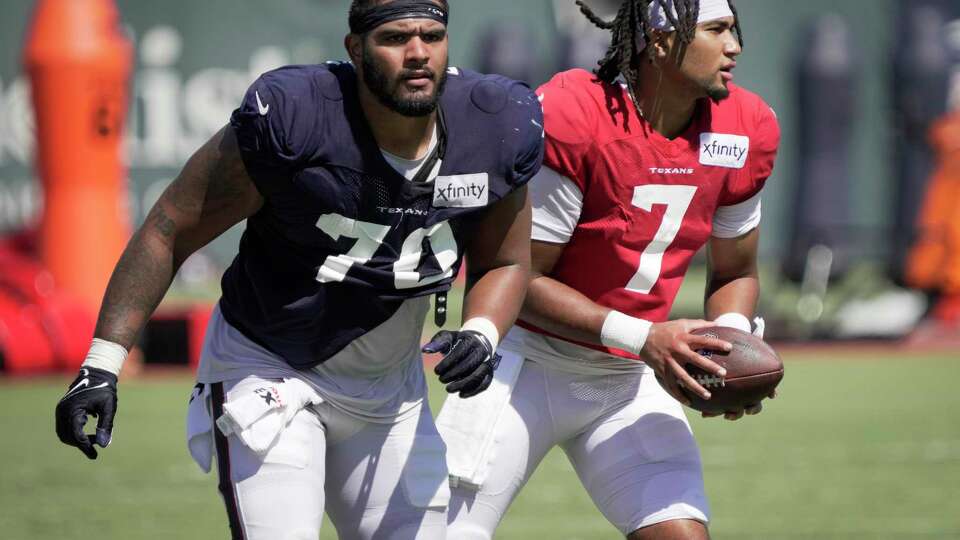 Houston Texans center Juice Scruggs (70) and quarterback C.J. Stroud (7) work extra after practice during an NFL training camp Wednesday, Aug. 16, 2023, in Houston.