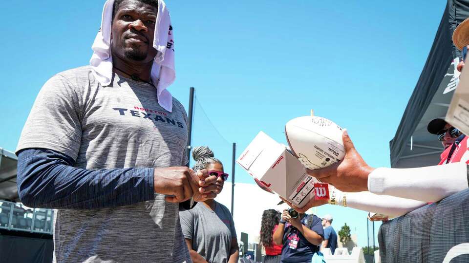 Former Houston Texans wide receiver Andre Johnson signs autographs during an NFL training camp Thursday, Aug. 17, 2023, in Houston.