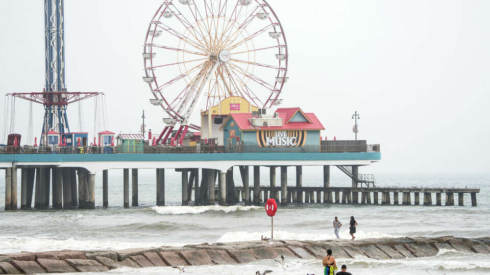 Beach goers walk along the jetties near Galveston's Pleasure Pier on Monday, March 6, 2023 in Galveson.