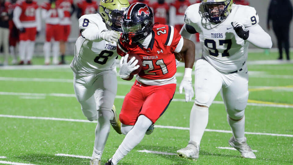 Westfield running back Taji Atkins (21) makes a gain in front of Klein Collins defenders Bryce Adeokun (8) and Mason Faye (97) during the first half of their Region II-6A Division 1 area playoff high school football game held at Tomball ISD Stadium Friday, Nov. 18, 2022 in Tomball, TX.