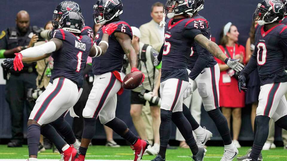 Houston Texans linebacker Denzel Perryman (6) celebrates with his teammates after intercepting a pass by Miami Dolphins quarterback Tua Tagovailoa during the first half an NFL preseason football game Saturday, Aug. 19, 2023, in Houston.