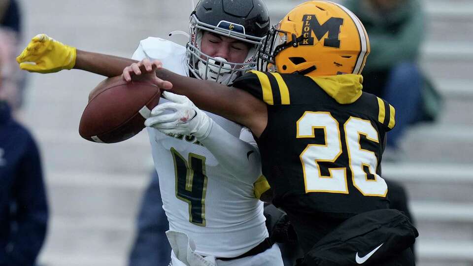 Fort Bend Marshall linebacker Joshua Lair (26) breaks up a pass intended for Lake Creek quarterback Eli Morcos (4) during the second half of a Region III-5A Division II high school football semifinal playoff game, Friday, Nov. 25, 2022, in Houston.