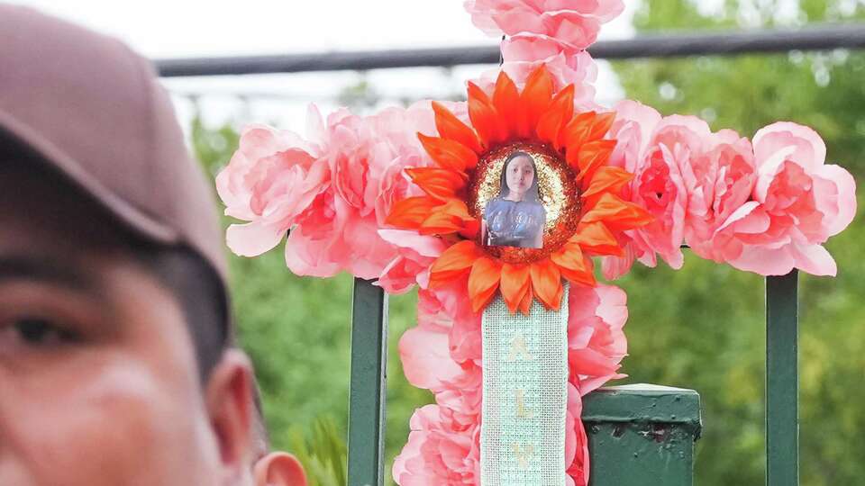 A cross with a photo of Maria Gonzalez is part of a memorial while her father, Carmelo Gonzalez, addresses the media in front of it on Monday, Aug. 21, 2023 in Pasadena. Gonzalez's 11-year-old daughter, Maria was murdered in their apartment last week. Juan Carlos Garcia-Rodriguez was arrested in Louisiana and charged with capital murder.