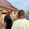 Schenectady native Michael 'Merlin' Davis, 50, who produces beats, chats with his brother Ural, 55, a DJ, in front of the closing Drome Sound Music Store on Monday.