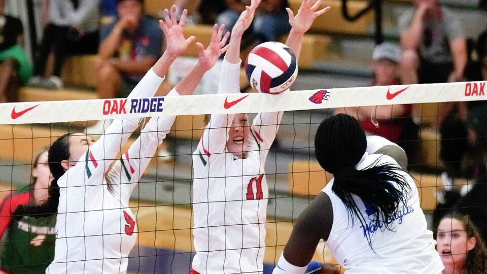 The Woodlands' Arden Blake (11) blocks a shot by Oak Ridge's Luvina Oguntimehin (18) during the first set of a District 13-6A high school volleyball match at Oak Ridge High School, Tuesday, Aug. 22, 2023, in Oak Ridge North.