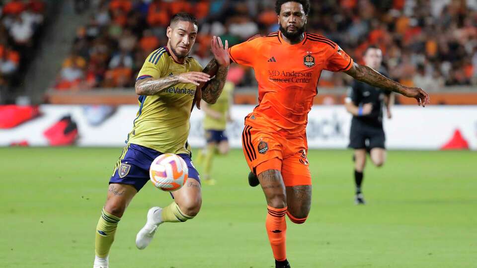 Real Salt Lake forward Cristian Arango, left, and Houston Dynamo defender Micael, right, push off each other as they chase the ball during the first half of a U.S. Open Cup soccer semifinal soccer match Wednesday, Aug. 23, 2023, in Houston. (AP Photo/Michael Wyke)