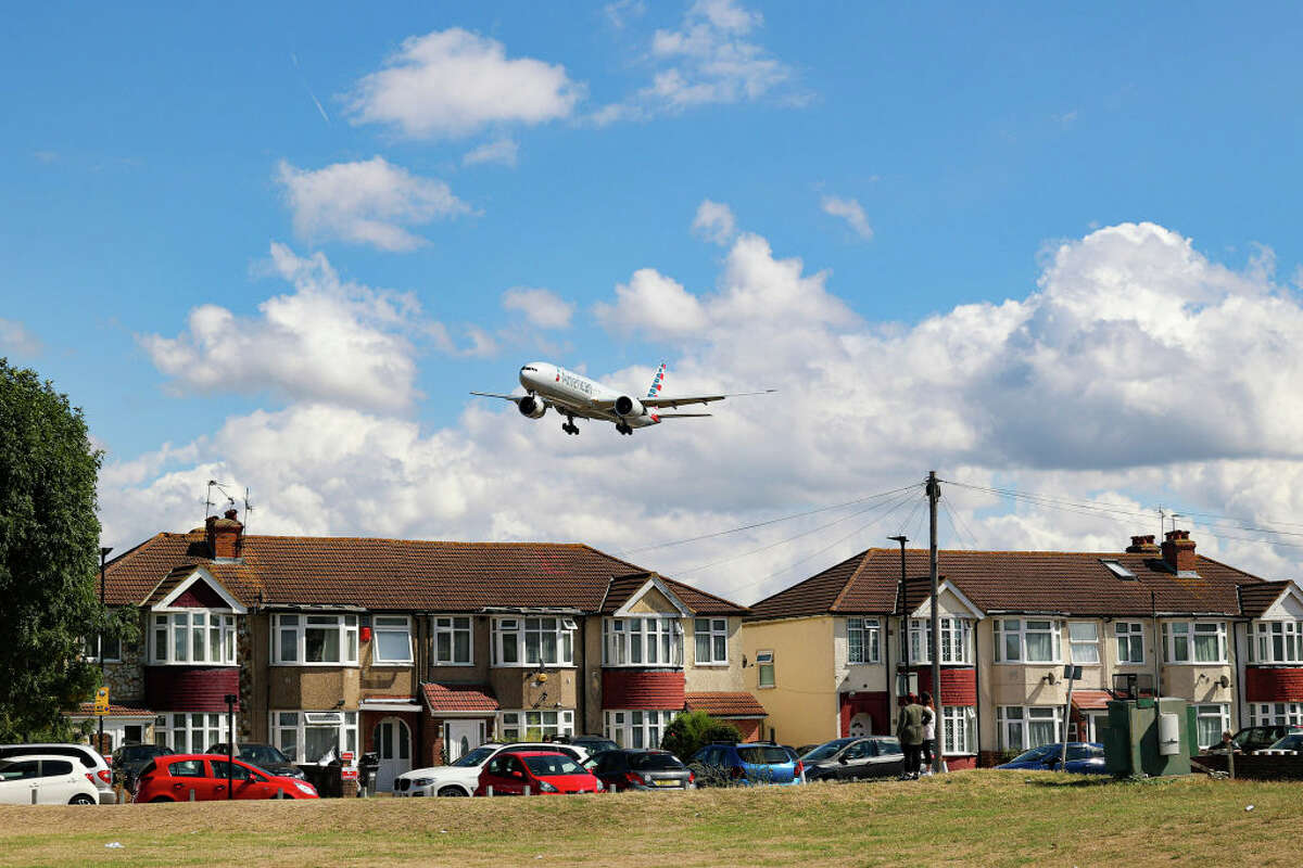 A Boeing 777-300ER from American Airlines arriving at London Heathrow Airport flying above the houses in Myrtle Avenue.