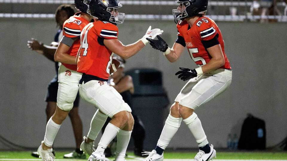 Katy Seven Lakes tight end Carter Hatten, left, celebrates with Peter Noonan after catching a 37-yard pass during the first half of a non-district high school football game at Legacy Stadium, Thursday, Aug. 24, 2023, in Katy.