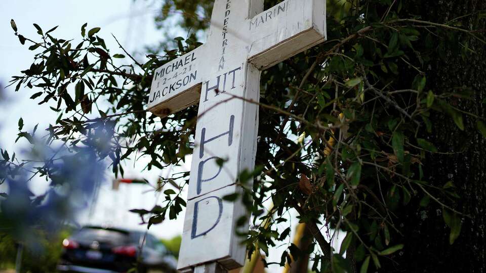 A cross and artificial flowers sit at the corner of Reed Road and Scott Street near where Michael Jackson was hit by a Houston Police vehicle in 2021 while he was walking on the sidewalk, photographed on Friday, Aug. 25, 2023 in Houston.