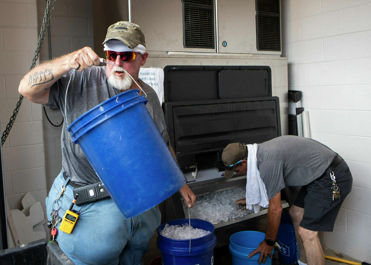 Katy ISD operations staffer Ronald Kratz helps load buckets filled with ice for coolers and misting fans to cool players off before a non-district high school football game at Rhodes Stadium, Thursday, Aug. 24, 2023, in Katy. The game between Morton Ranch and Aldine Eisenhower was pushed back due to heat-related concerns. “We can’t put the ice out like we normally would with this heat,” Kratz said. “It’ll just melt before the players get a chance to really use it.”