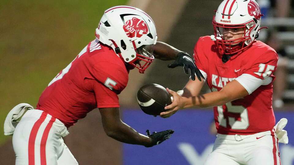 Katy quarterback Gunner Nelson (15) hands the ball off to running back Romel Jordan (5) during the second quarter of a non-district high school football game at Rhodes Stadium, Saturday, Aug. 26, 2023, in Katy.