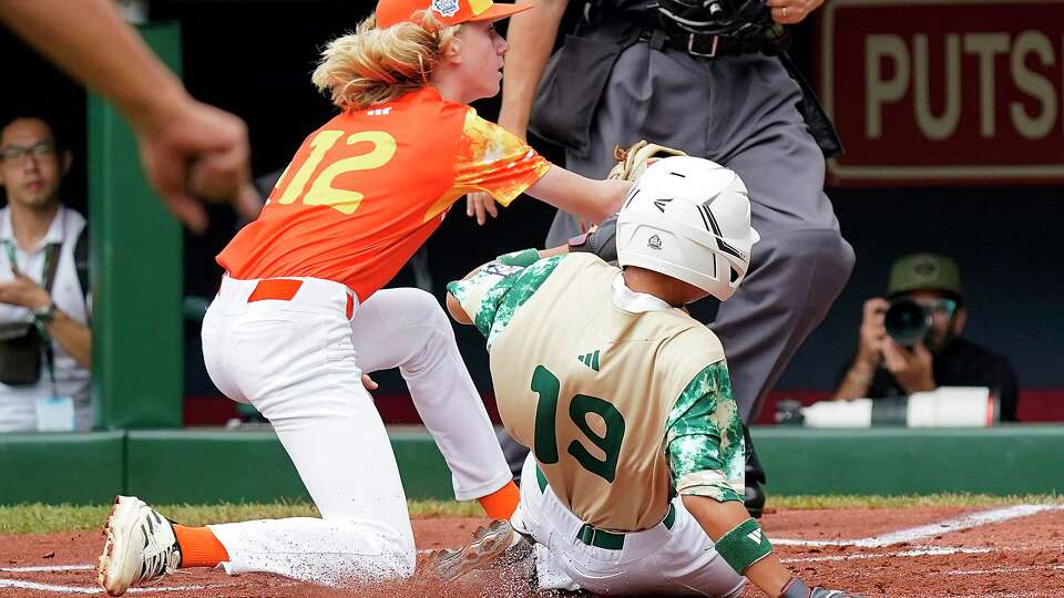 Taiwan's Chen Kai-Sheng (19) scores on a passed ball as Needville, Texas pitcher Colten Georgi (12) covers the plate during the first inning of a baseball game at the Little League World Series tournament in South Williamsport, Pa., Sunday, Aug. 27, 2023. (AP Photo/Tom E. Puskar)