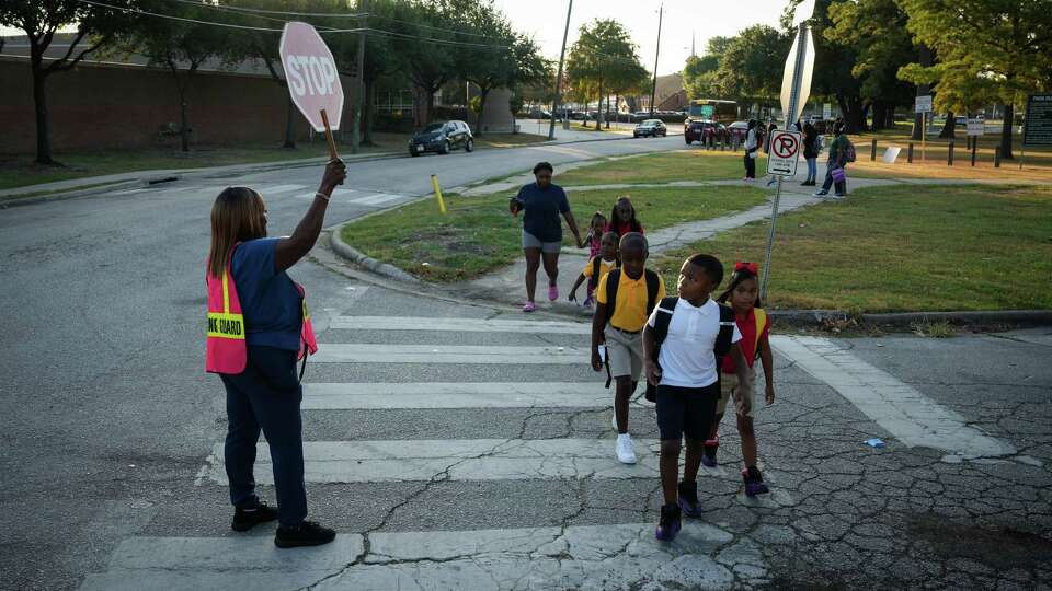 Students cross Solo Street at Sonora Street on their way first day of school Monday, Aug. 28, 2023, near Henderson Elementary School in Houston.