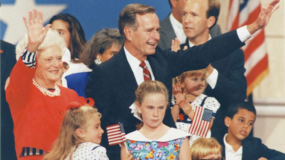 08/19/1992 - Pres. George H.W. Bush joins his wife, Barbara, and their grandchildren on the podium during the third night of the 1992 Republican National Convention in the Houston Astrodome. First Lady Barbara Bush had just addressed the convention with a seven-minute speech that emphasized family values of integrity, strength, pride, and glowing references to her husband. President Bush made a surprise appearance at the convention after the speech Wednesday night.