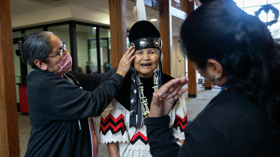 Myra Battise helps newly elected second chief Millie Thompson Williams with her official regalia after a press conference on Monday, January 3, 2023. Battise nominated Williams for the leadership role. Williams is the first female elected as a chief in the tribe's history.