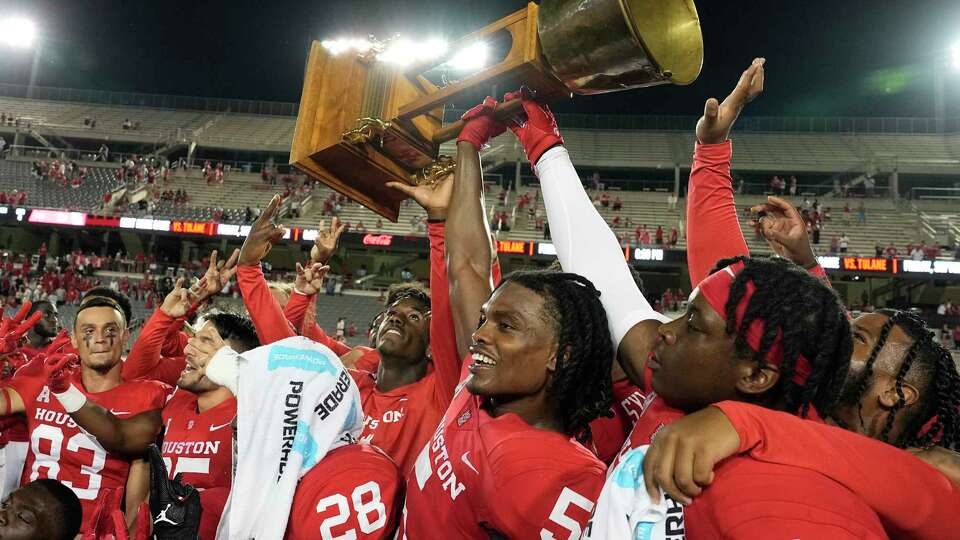 Hasaan Hypolite (5) and the Houston Cougars hoist the Bayou Bucket after defeating the Rice Owls in a football game Saturday, Sept. 24, 2022, in Houston.