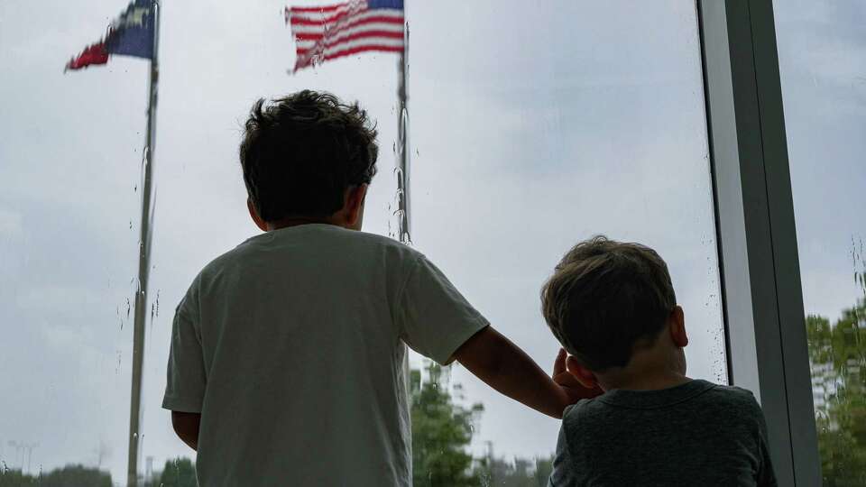 Mateo Tamez, 5, and Emilio Tamez, 2, wait out the rain at the Lone Star Flight Museum on Monday, Sept. 4, 2023, in Houston.