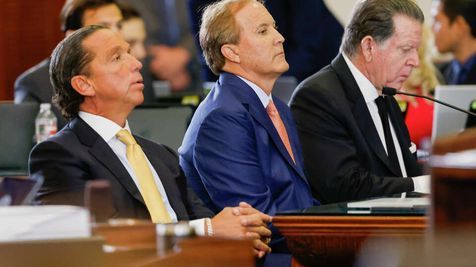 Texas Attorney General Ken Paxton (center) sits with his lawyers Tony Buzbee (left) and Dan Cogdell (right) at the beginning of the first day of Paxton's impeachment trial in the Texas Senate chambers at the Texas State Capitol in Austin on Tuesday, Sept. 5, 2023. The Texas House, including a majority of its GOP members, voted to impeach Paxton for alleged corruption in May. (Juan Figueroa/Pool via The Dallas Morning News)