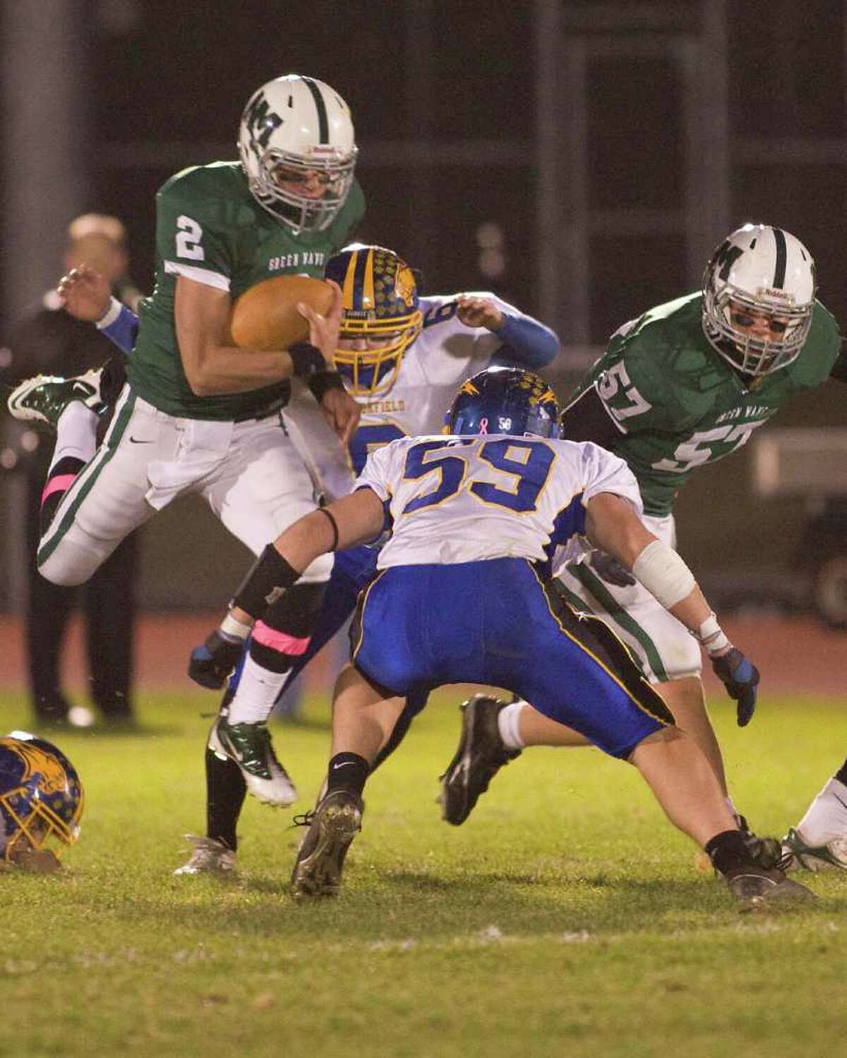 New Milford quarterback Karl Bradshaw (2) goes airborne, but Brookfield's Tyler Heckmann (59) is waiting for him when he comes down Friday night, Oct. 22, 2010, at New Milford High School.