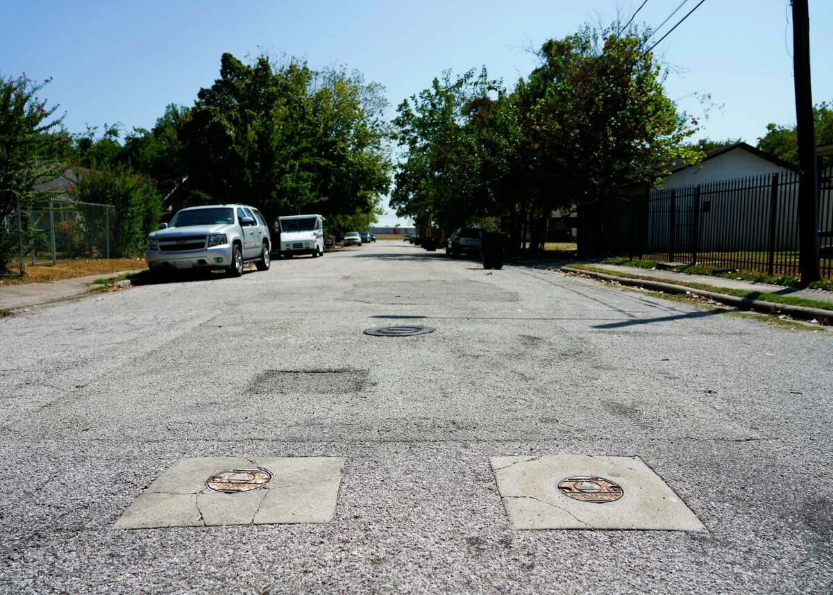Well covers in the road where samples of water are pulled from are seen along Lavender Street, near homes across from the Southern Pacific rail yard, Friday, Sept. 8, 2023, in Houston.