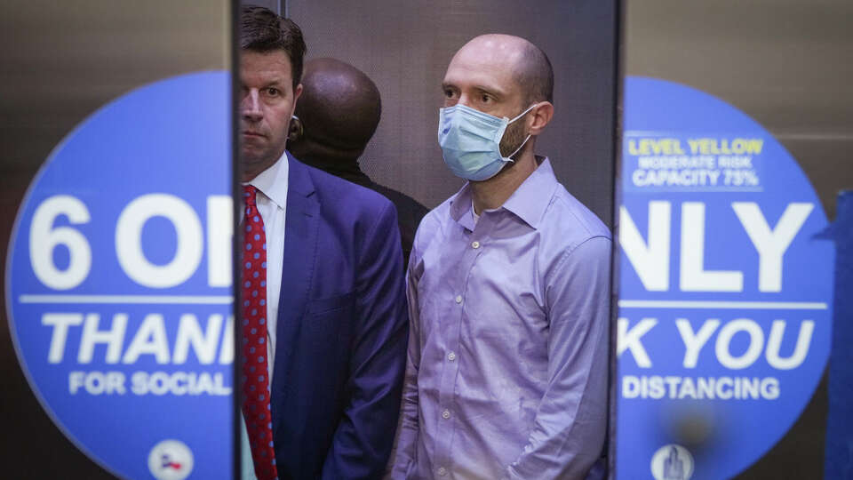 Aaron Dunn stands in the elevator after leaving the courtroom after COVID contract indictments were handed down Tuesday, April 12, 2022 in Houston. Two aides to Harris County Judge Lina Hidalgo and former aide, all indicted on criminal charges amid an investigation in a since-canceled vaccine outreach contract, appeared in court Tuesday. Dunn, who recently left her office, was indicted on two felony charges of misuse of official information and tampering. Wallis Nader and Alex Triantaphyllis, who work for Hidalgo, were indicted on the same charges.