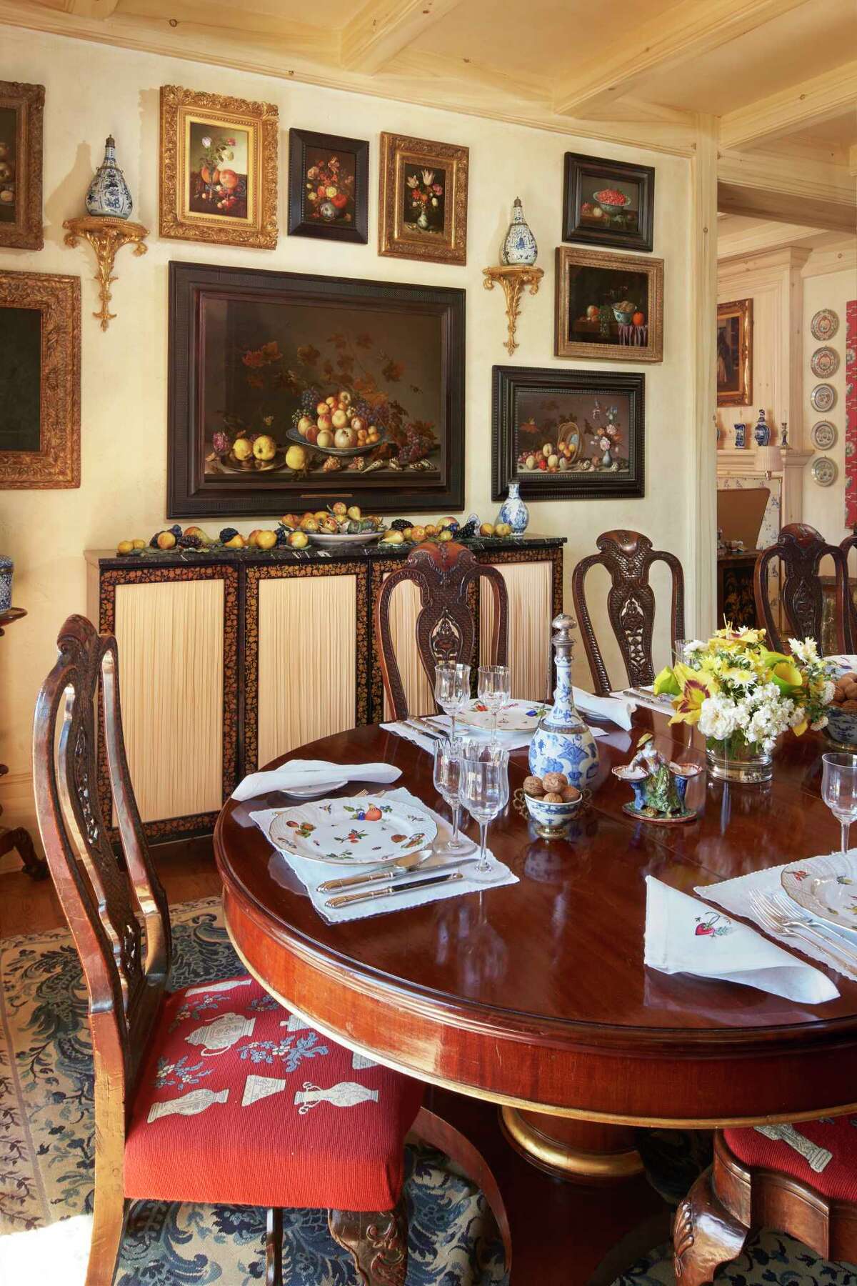 Dining room at Wheatland, the Yuba County family home of Ann Getty.  Still life paintings of fruit including the central work by Balthasar van der Ast are displayed on the walls along with Dutch porcelain Delft fruit on the sideboard below. 