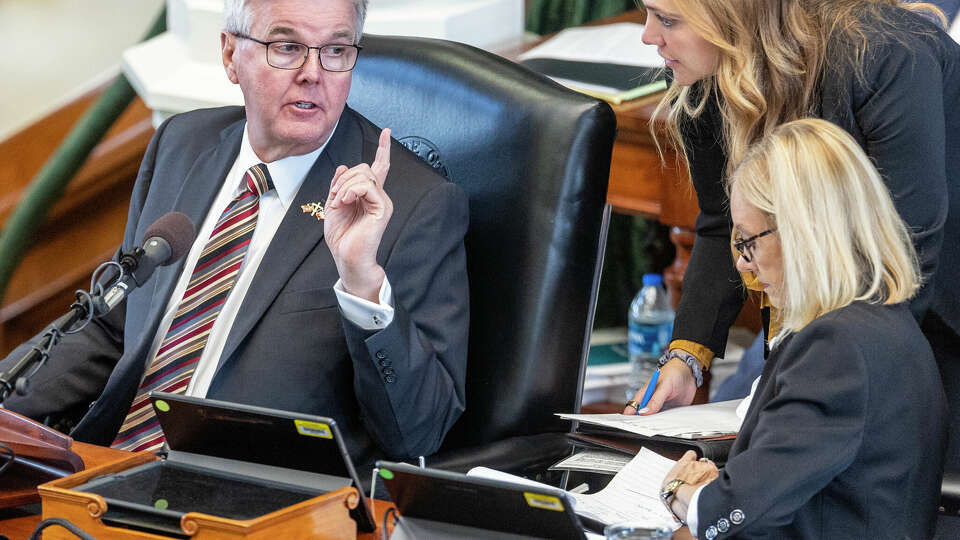 Texas Lt. Gov. Dan Patrick confers Thursday, Sept. 14, 2023, on the Senate floor in the Capitol in Austin with his officials during the impeachment trial of suspended Attorney General Ken Paxton.