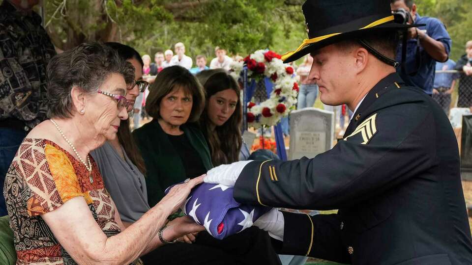 Ellen Dyer, left is presented an American flag by Staff Sgt. Sayre McGoldrick during a graveside ceremony for her uncle, U.S. Army Air Corps Tech Sgt. Elton Gomillion, at Lake Grove Cemetery on Thursday, Sept. 14, 2023 in Iola. Sgt. Gomillion was killed in a WWII bomber crash in 1943 but was identified in March using DNA analysis. He was buried Thursday near his hometown of Iola, in northern Grimes County, next to his father and mother.