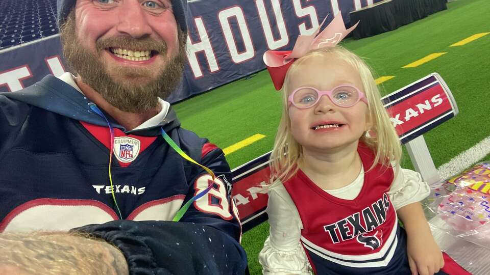 Texans season-ticket holder Jefferson Lee shares a moment with one of his two daughters.