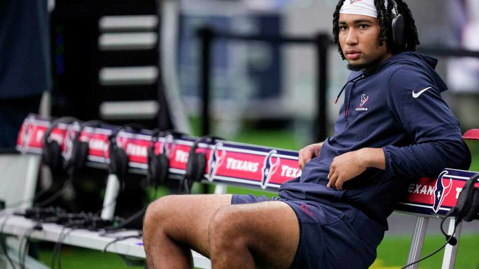 Houston Texans quarterback C.J. Stroud sits on the bench watching his teammates warm up before an NFL football game against the Indianapolis Colts Sunday, Sept. 17, 2023, in Houston.