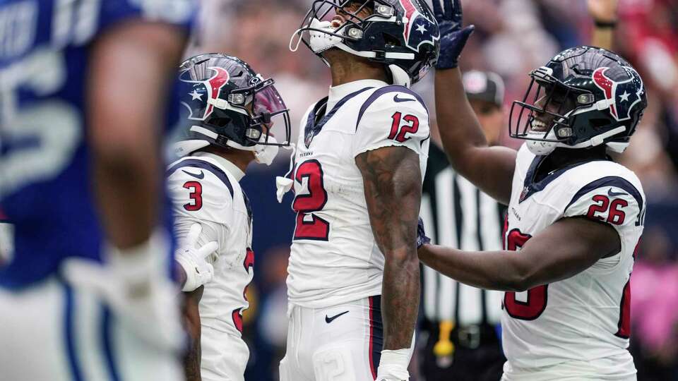 Houston Texans wide receivers Nico Collins (12), Tank Dell (3) and running back Devin Singletary (26) celebrate Collins' 8-yard touchdown reception against the Indianapolis Colts during the first half an NFL football game Sunday, Sept. 17, 2023, in Houston.