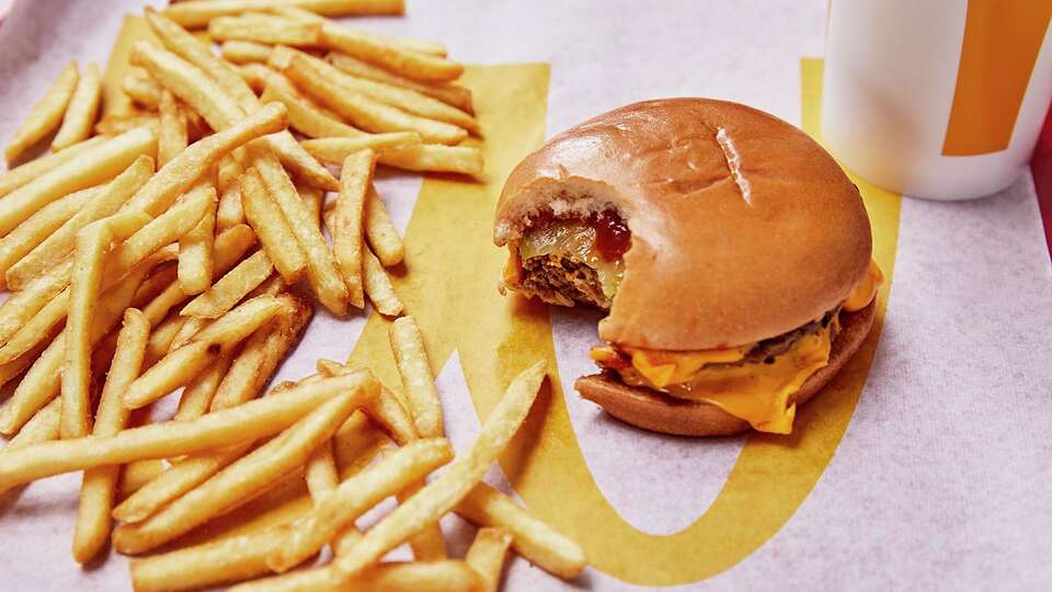 Photo of McDonald's Double Cheeseburger with a side of fries and a drink. 