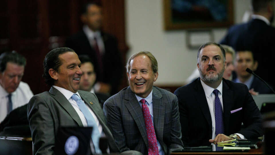 Texas Attorney General Ken Paxton, center, sits between defense attorneys Tony Buzbee, left, and Mitch Little, right, before starting the ninth day of his impeachment trial in the Senate Chamber at the Texas Capitol on Friday, Sept. 15, 2023, in Austin, Texas.